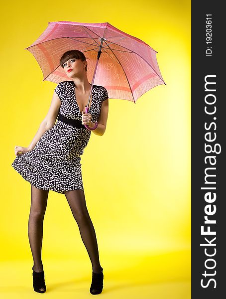 woman posing with rose umbrella pin-up style on yellow. woman posing with rose umbrella pin-up style on yellow