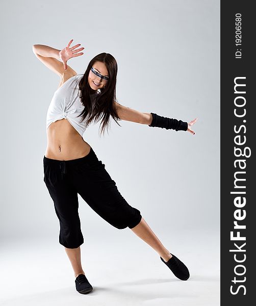 Cool looking dancer posing on a grey background. Cool looking dancer posing on a grey background