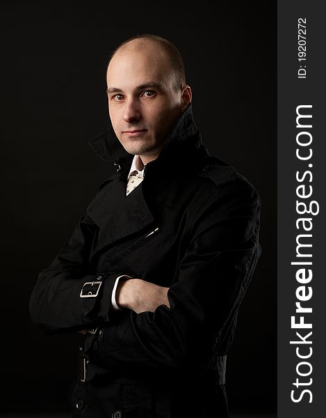 Portrait of young man thinking, black background