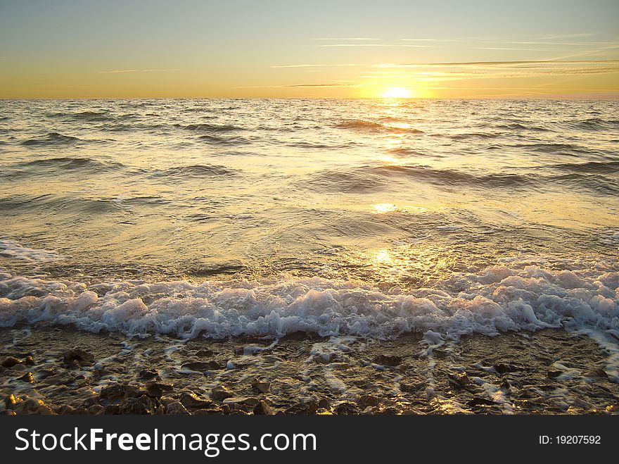 Golden sea sunset with braking waves