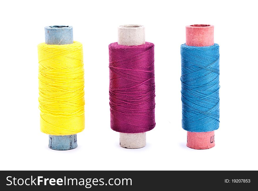 Three vintage paper multi colored thread coils on white background (blue, yellow and lilac). Three vintage paper multi colored thread coils on white background (blue, yellow and lilac)