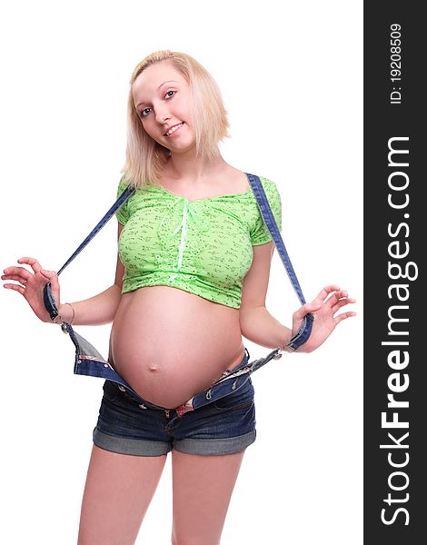 Young pretty pregnant woman posing in jeans overalls