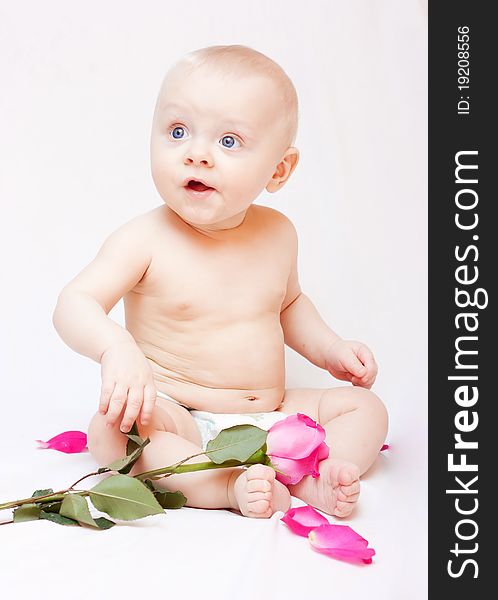 Newborn baby lying in a bed with pink roses. Newborn baby lying in a bed with pink roses