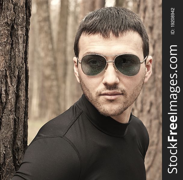 Young man in black clothes and sunglasses closeup portrait. Young man in black clothes and sunglasses closeup portrait