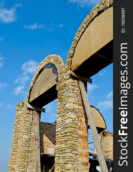 Erection of walls with arched window openings with natural stone. Erection of walls with arched window openings with natural stone.