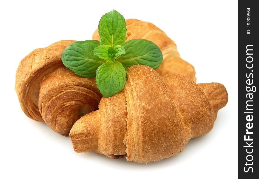 Fresh croissants with mint on a white background