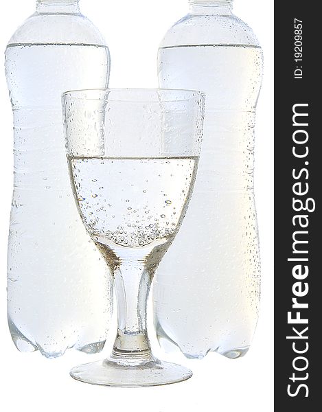 Mineral water in a glass and bottles on the white isolated background