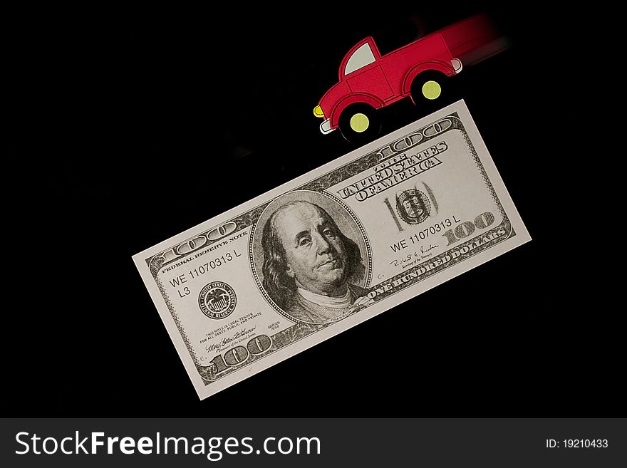 A red truck speeds down a hundred dollar bill. A red truck speeds down a hundred dollar bill.