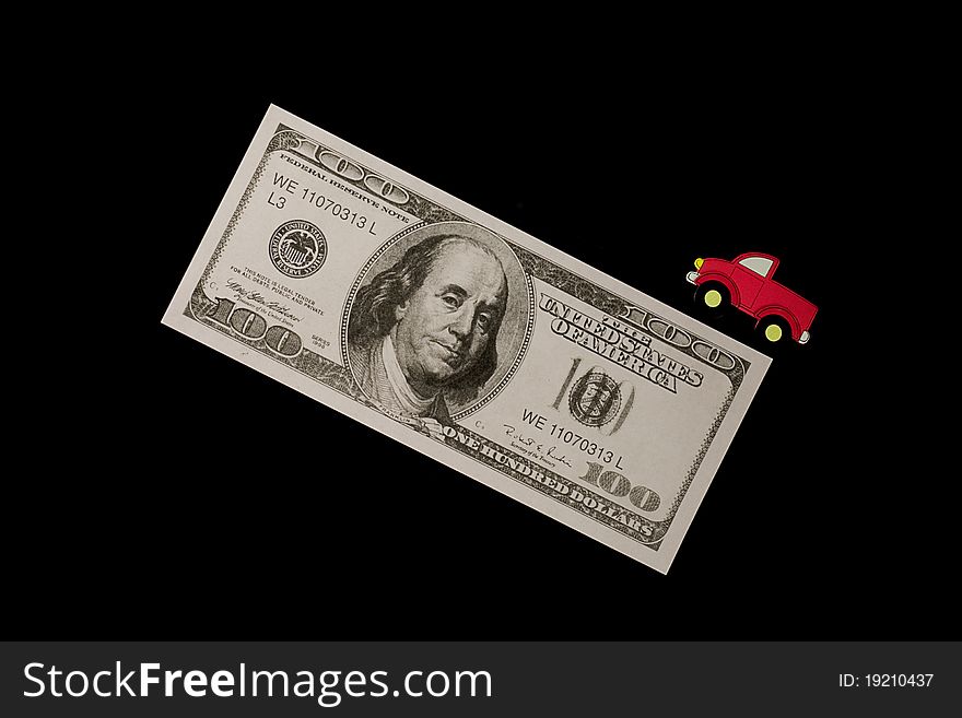 A small truck on a large hundred dollar bill. A small truck on a large hundred dollar bill.