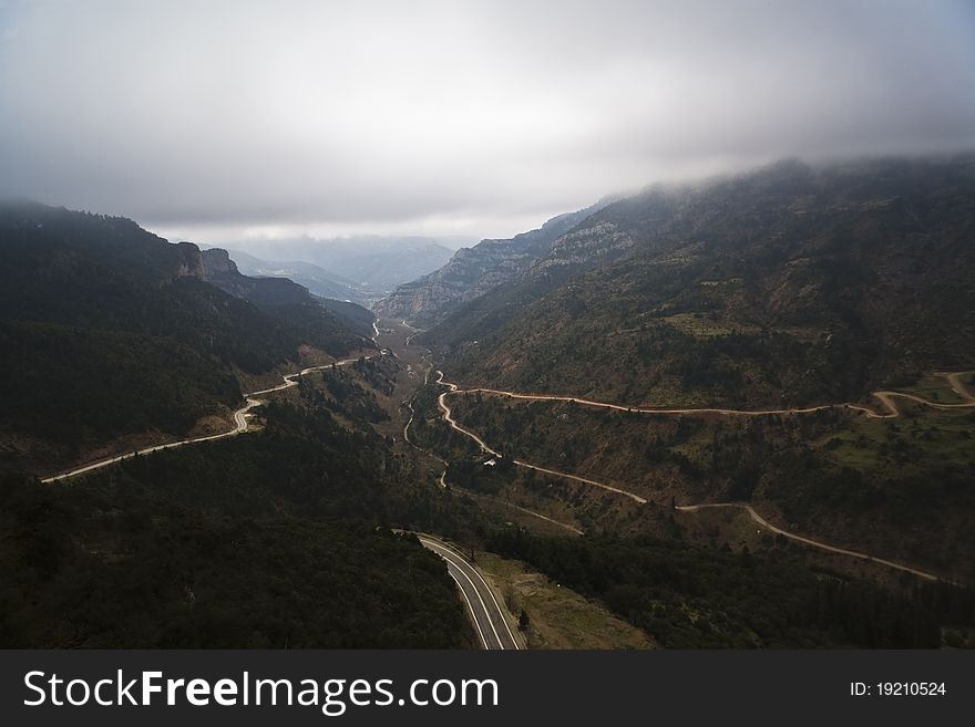 View From the Monastery of Mega Spileon.Spectacular view of winding roads cutting through Peloponessos mountains in Greece on a cloudy day.