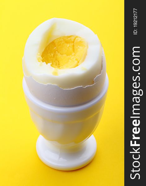 Egg in cup on yellow