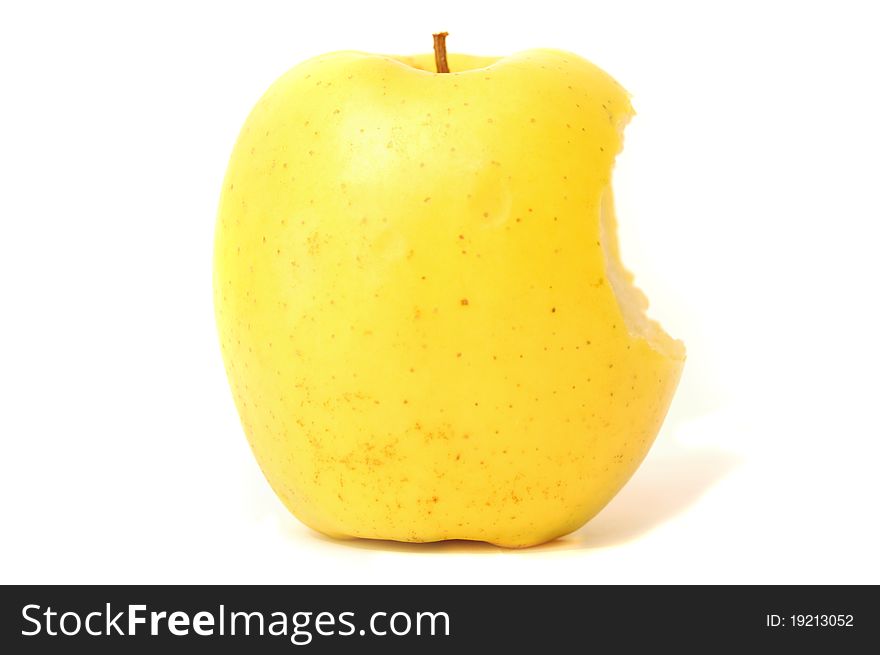 The bitten off yellow apple on a white background