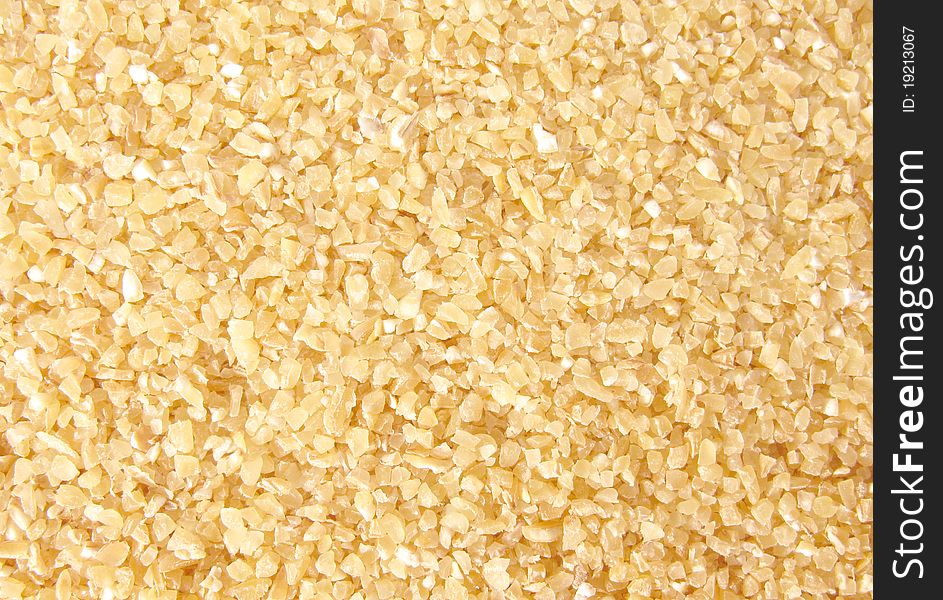 A handful of crude wheat groats background.