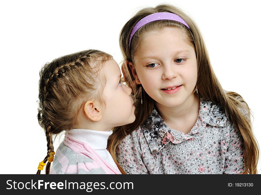 An image of a girl telling a secret to her sister