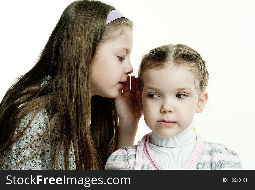 An image of a girl telling a secret to her sister