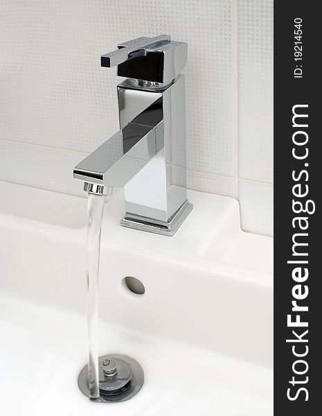 Closeup of modern bathroom tap, flowing tap water