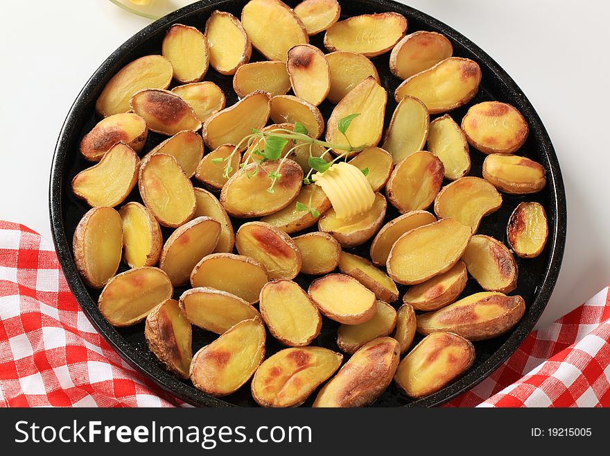 Halves of roasted potatoes and butter - detail