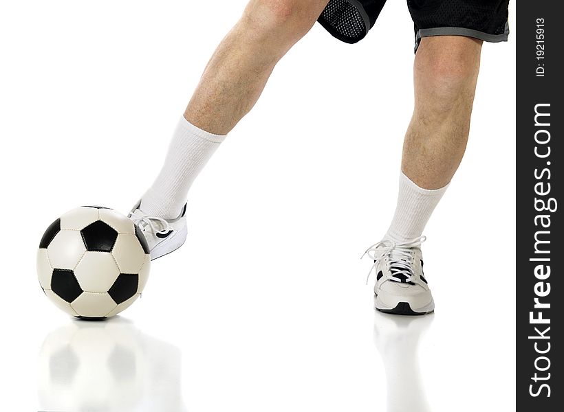 The legs of a senior athlete in shorts and sneakers kicking a soccer ball.  Isolated on white. The legs of a senior athlete in shorts and sneakers kicking a soccer ball.  Isolated on white.