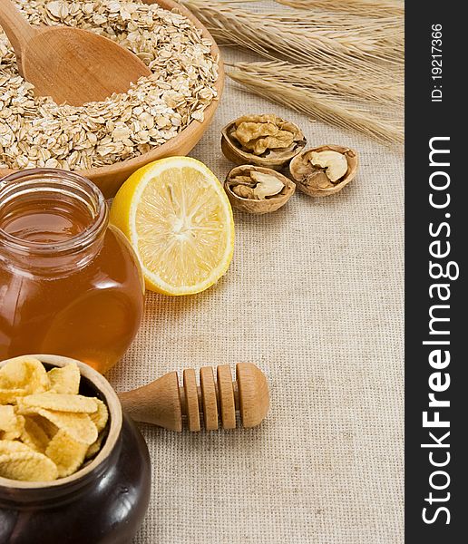 Plate of oat, honey and healthy food on sacking