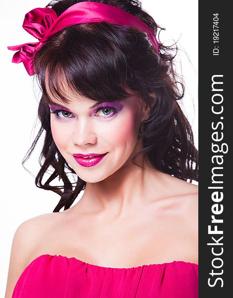 Portrait of beautiful girl with dark long curly hair and vibrant Make-up wearing pink satiny ribbon on white background. Portrait of beautiful girl with dark long curly hair and vibrant Make-up wearing pink satiny ribbon on white background