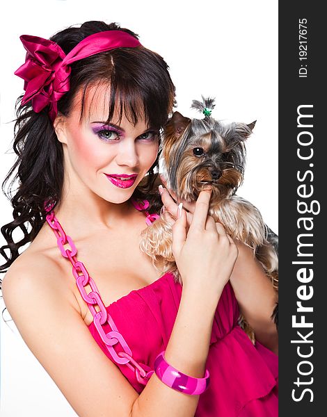Portrait of beautiful girl with dark long curly hair and vibrant make-up wearing pink satiny ribbon holding small dog on white background. Portrait of beautiful girl with dark long curly hair and vibrant make-up wearing pink satiny ribbon holding small dog on white background