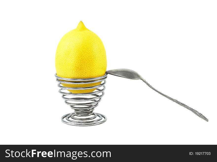 Lemon in the eggcup with spoon on the white background. Lemon in the eggcup with spoon on the white background