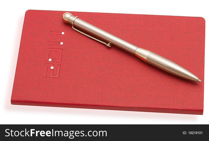 Red notebook and a pen on a white background