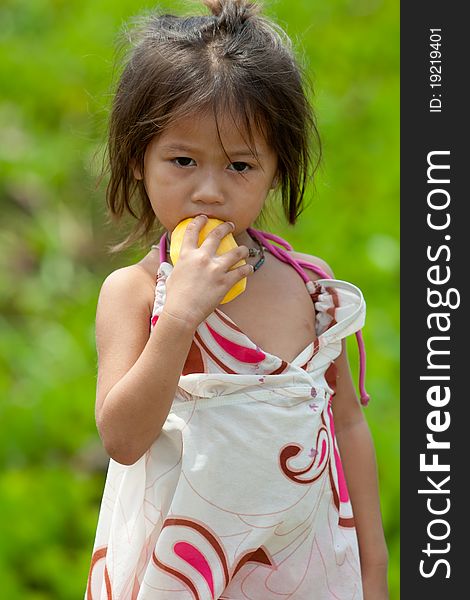 Portrait of asian girl, cute child eat a mango