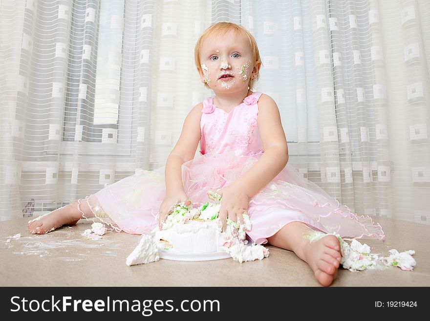 Girl enjoying her first birthday cake. Girl enjoying her first birthday cake