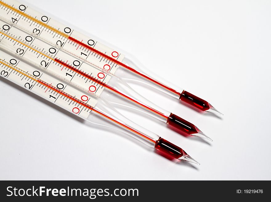 Three glass thermometers on white background