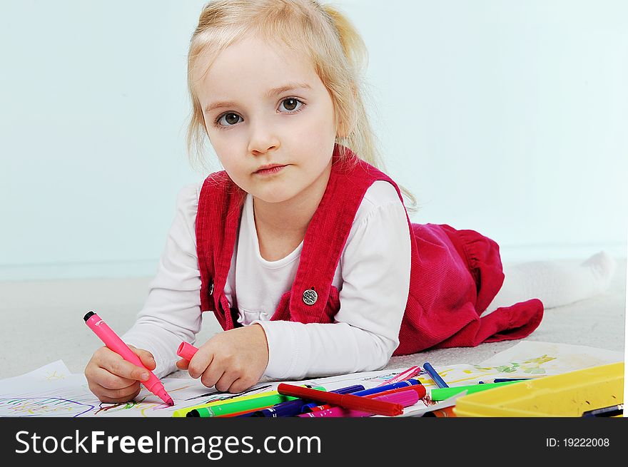 Beautiful little girl is drawing on paper