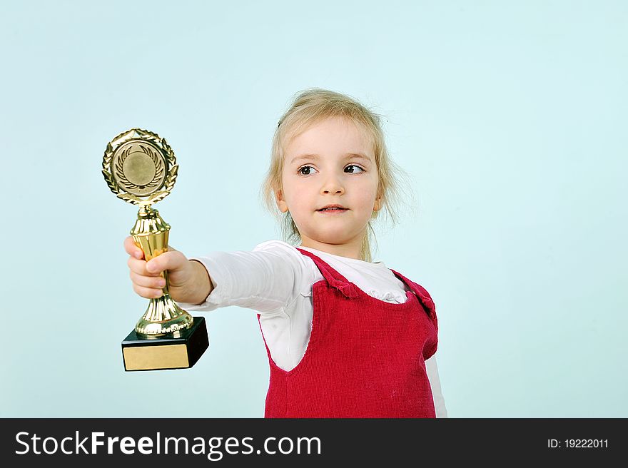 Lovely blond little girl with champion cup