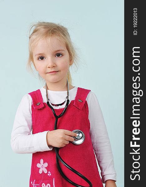 Little girl holding stethoscope and listens to the heartbeat. Little girl holding stethoscope and listens to the heartbeat