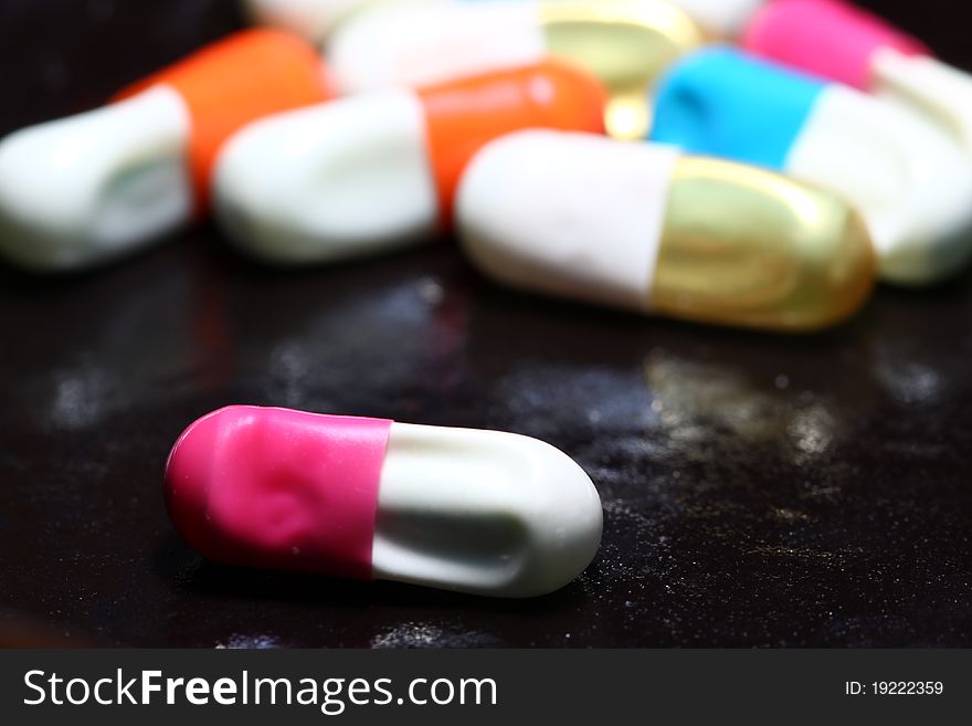 Closeup of spoilt pills on black background.