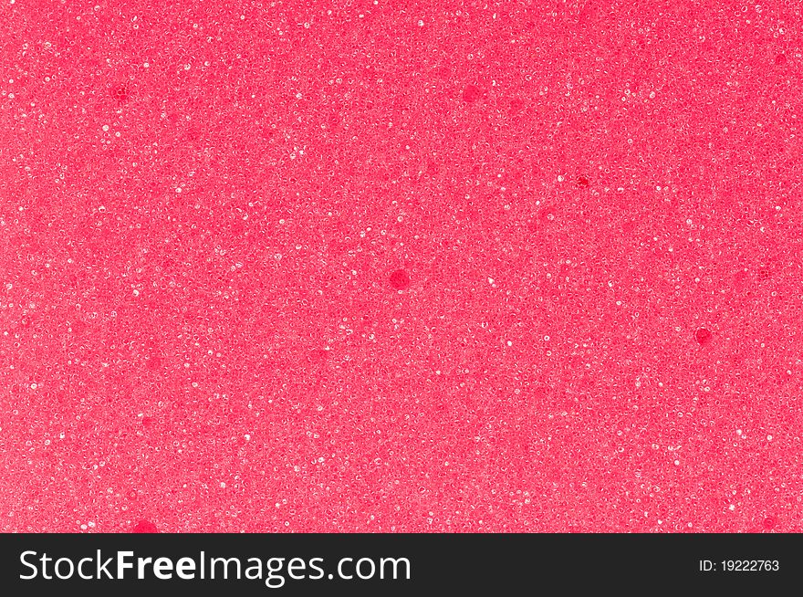 Close-up of a red cleaning sponge surface as a backdrop