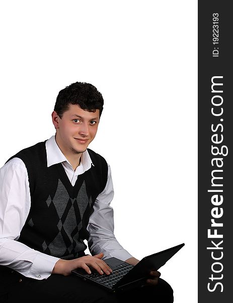 Portrait of the young man in a shirt and a vest with the opened laptop in hands. Portrait of the young man in a shirt and a vest with the opened laptop in hands