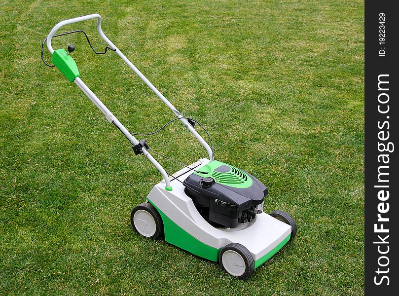 Lawnmower stand on the green grass. Lawnmower stand on the green grass