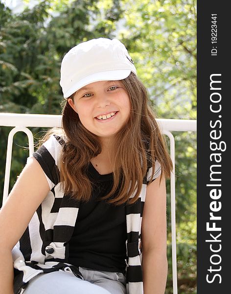 Portrait of a young girl with a cap smiling towards the camera. Portrait of a young girl with a cap smiling towards the camera