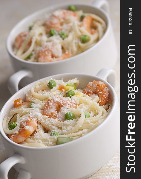 Lemony prawn and pea pasta topped with grated cheese. Lemony prawn and pea pasta topped with grated cheese