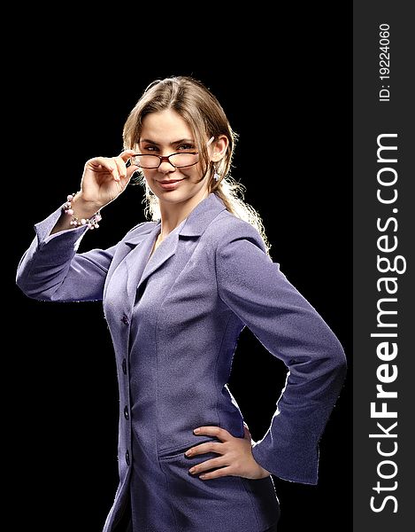 Beautiful young woman posing in business suit and glasses. Isolated over black background. Beautiful young woman posing in business suit and glasses. Isolated over black background