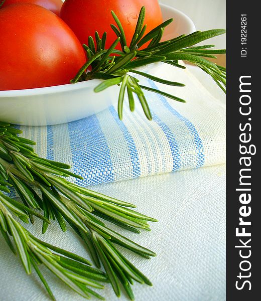 Fresh rosemary and tomatoes  on  table
