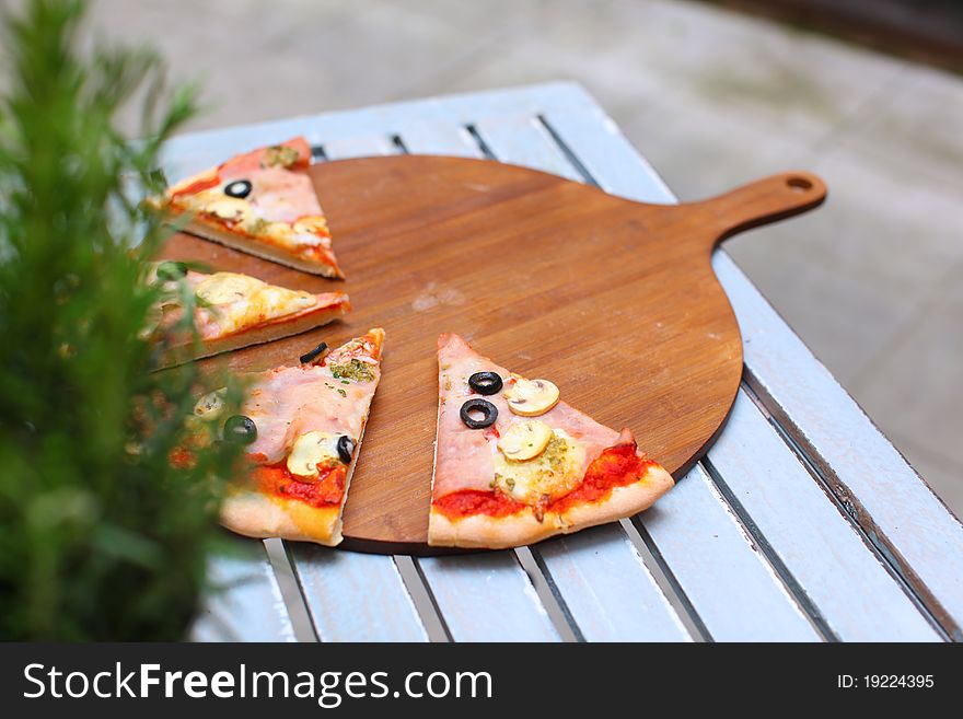 Pizza sliced on the wooden pizza board. Pizza sliced on the wooden pizza board