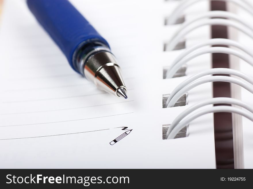 Macro view of blank spiral notebook and pen