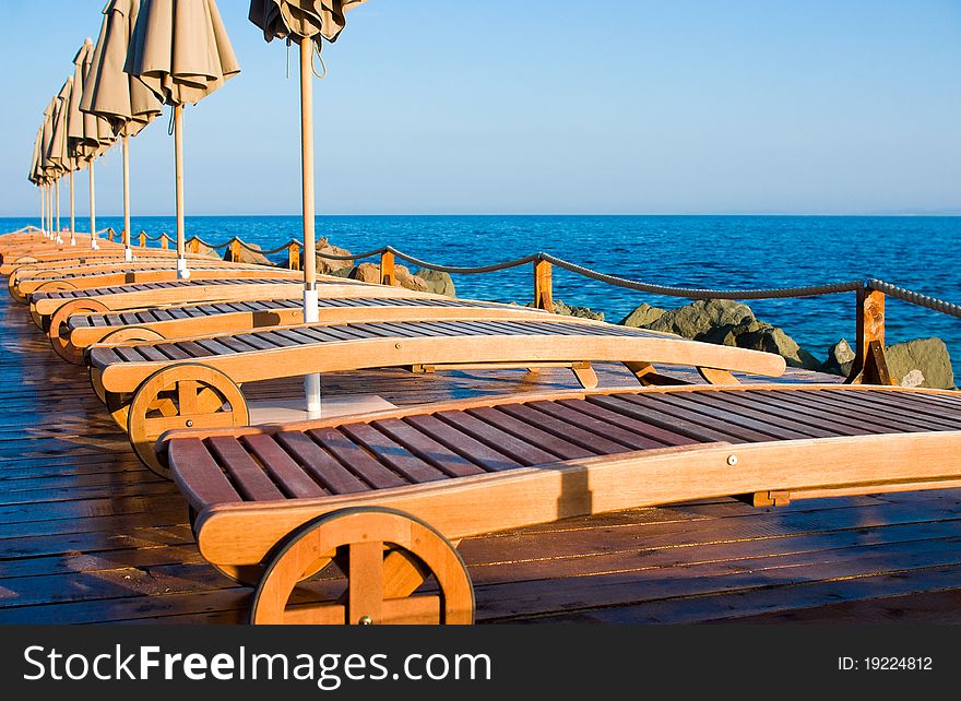 Sun loungers on a beach with a parasol.