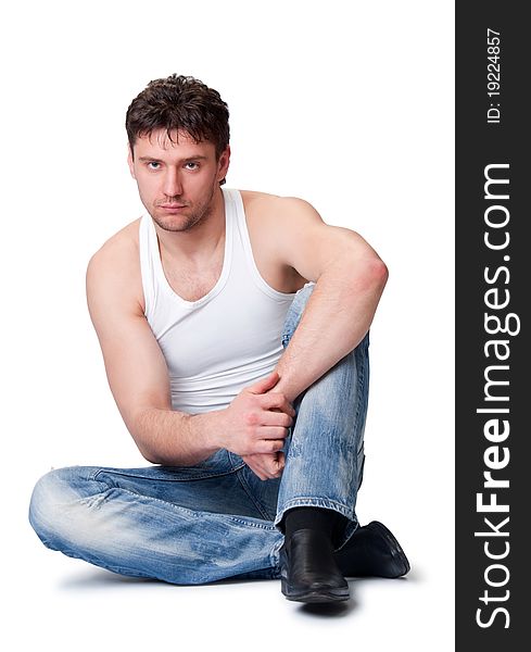 Man in jeans sitting on an isolated background