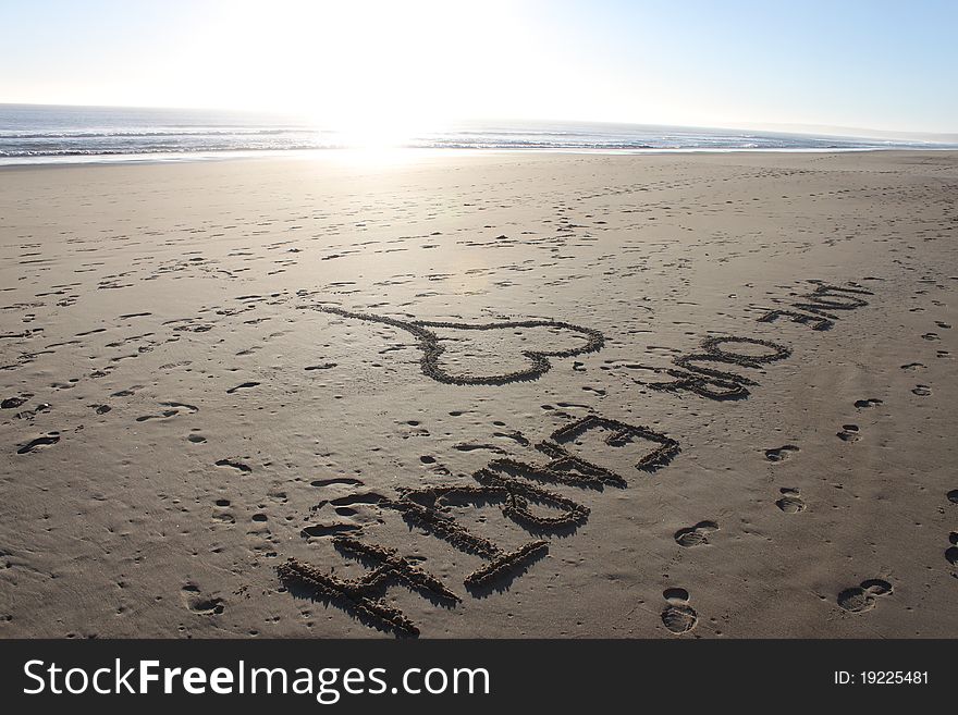 Love Our Earth Sketched into the Sand at the Beach near the Ocean