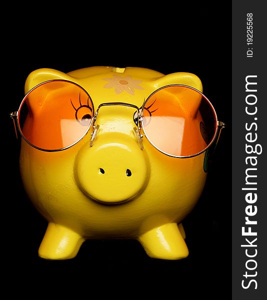 Yellow piggybank with sunglasses studio cutout