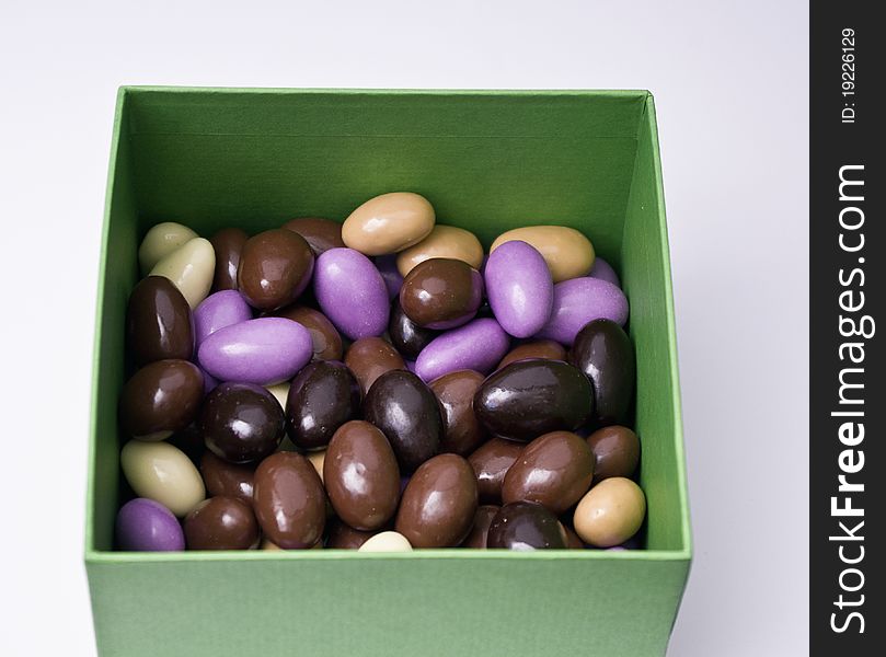 Chocolate almonds with diferent colors in a green box