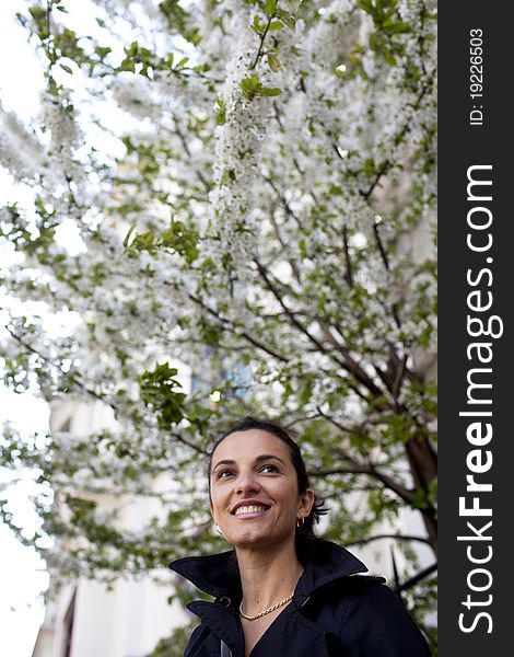 Woman standing in front of a tree with white blossoms. Woman standing in front of a tree with white blossoms