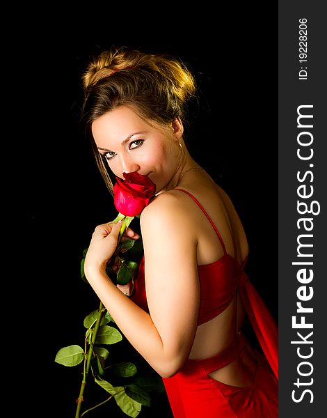 Girl in red dress and a red rose on a black background. Girl in red dress and a red rose on a black background